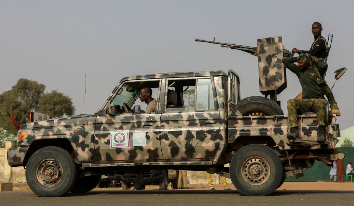 Security forces patrol as people wait for the arrival of the rescued schoolgirls